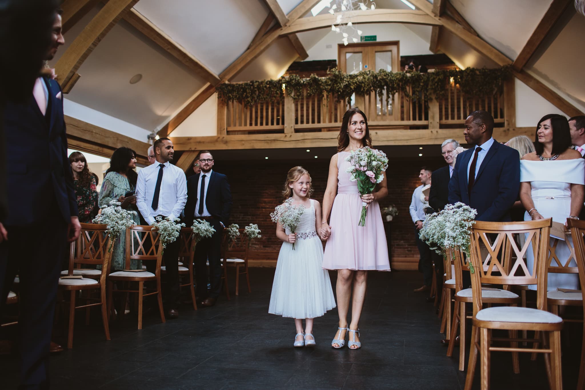Bridesmaids walking down the aisle at Mythe Barn