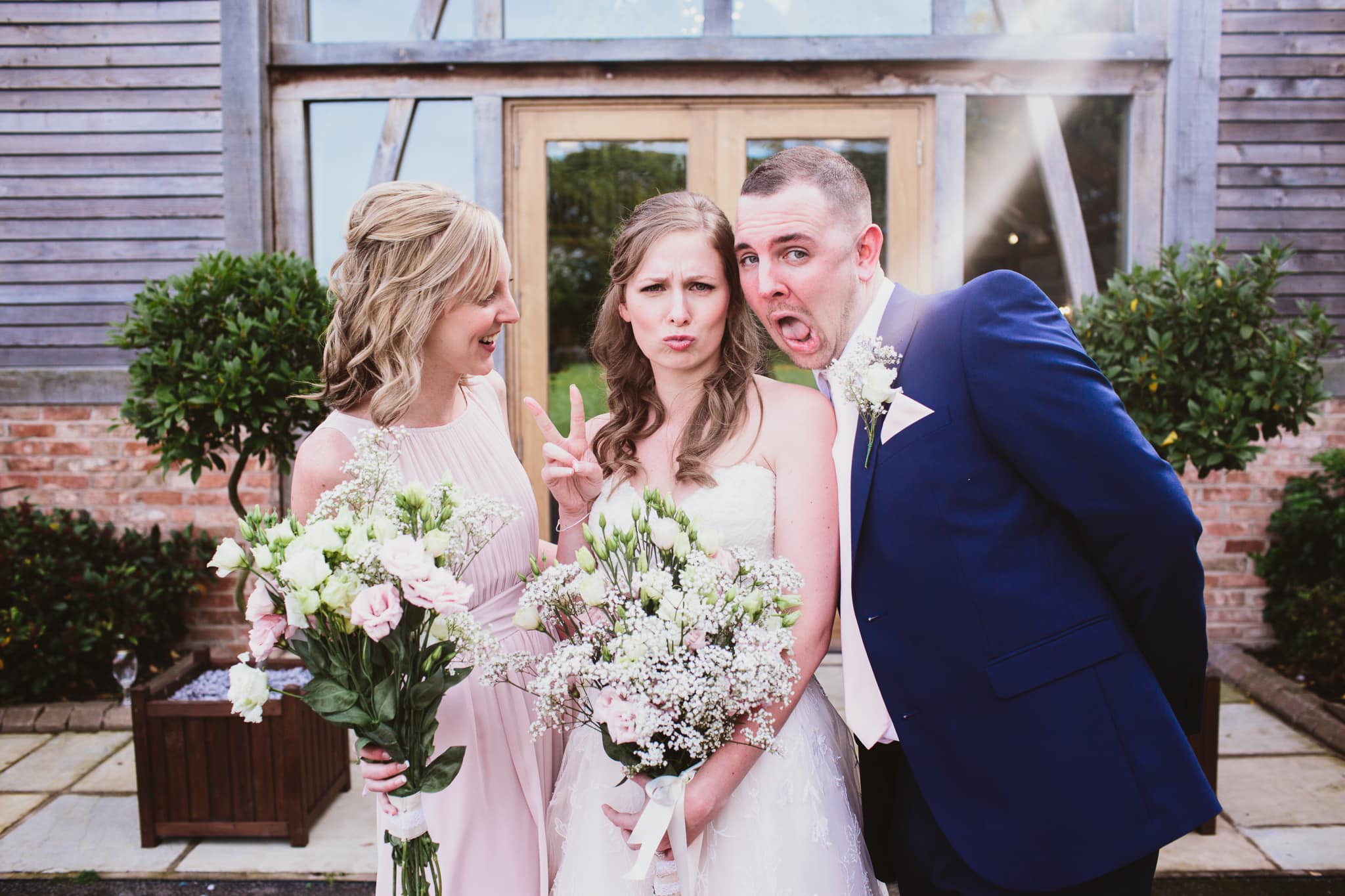 Wedding photography at Mythe Barn - bride and brother and sister pulling silly faces to camera
