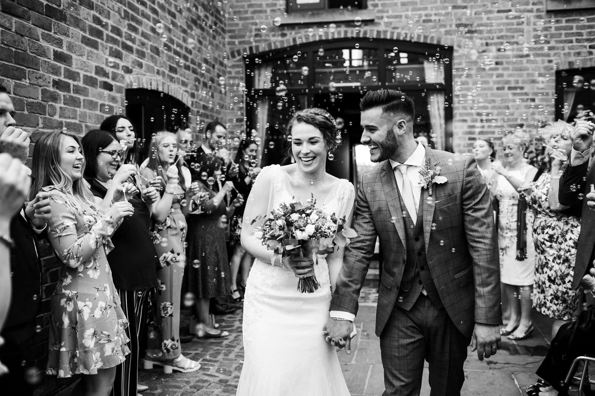 Wedding photography at Swancar Farm - walking out to bubbles black and white photo