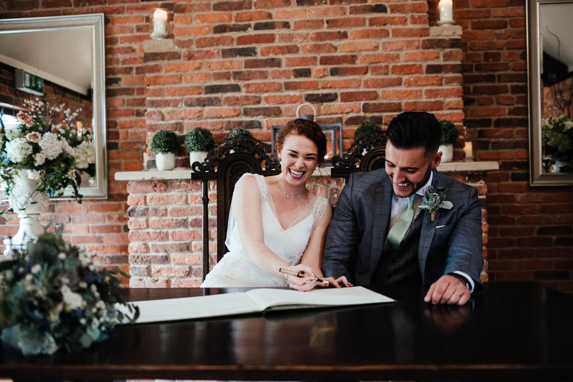 weddinrustic farm wedding photography - bride and groom sign the register