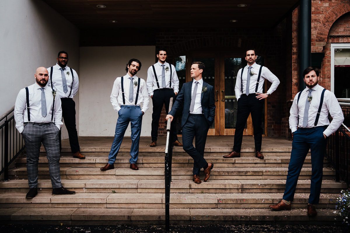 groom and groomsmen pose on steps outside Bridgford hall