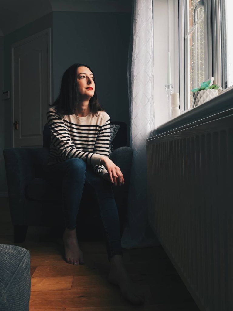 Amy sat in an armchair looking out of the window. Beautiful light on her face.