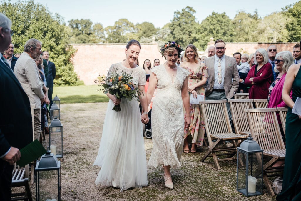 Brides walking into ceremony at Thorpe Garden