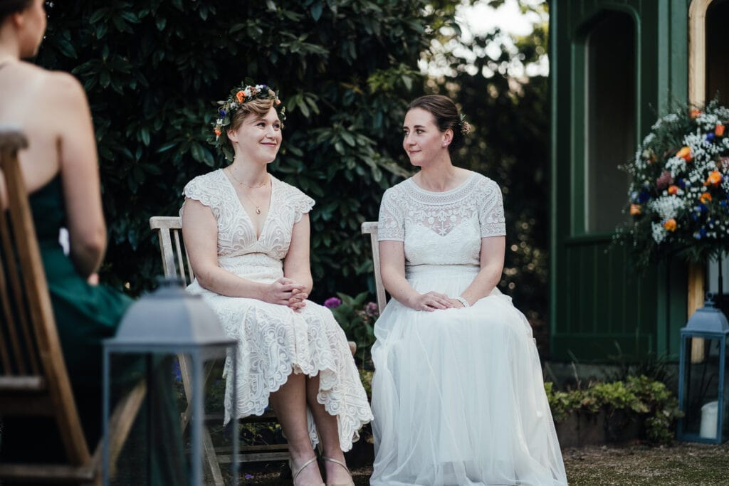 Wedding Photography at Thorpe Garden. Brides seated during outdoor ceremony