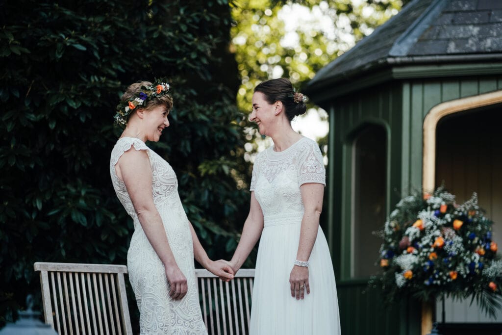 Wedding photography at Thorpe Garden. Outdoor ceremony with bride and bride laughing together.