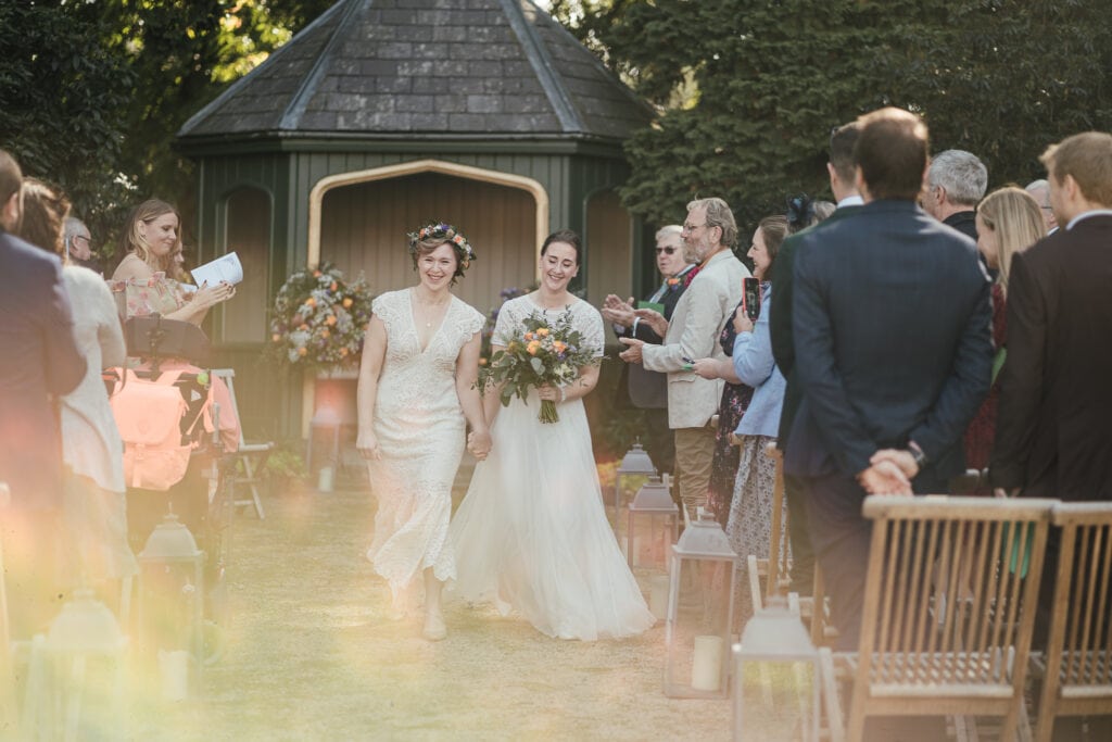 Brides walking back down the aisle. Wedding photography at Thorpe Garden
