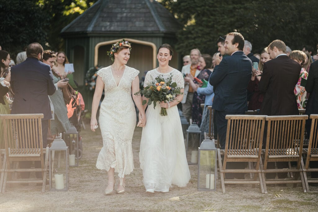 Wedding Photography at Thorpe Garden: Bride and bride walk back down the aisle after their ceremony.