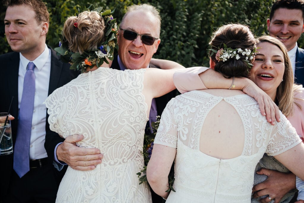 Brides hugging guests