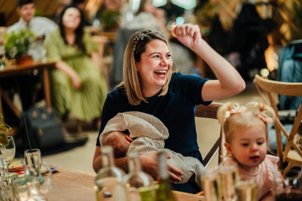 Wedding guest cheering and breast feeding