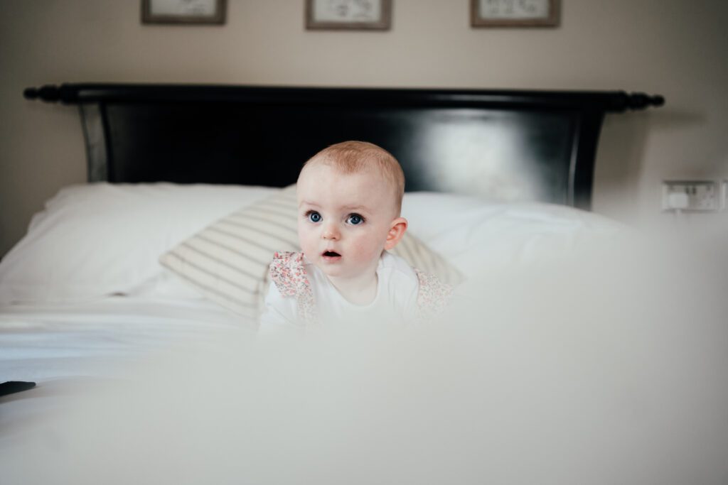 Wedding photography at Widbrook Grange: Jo and Huw's baby daughter on the bed