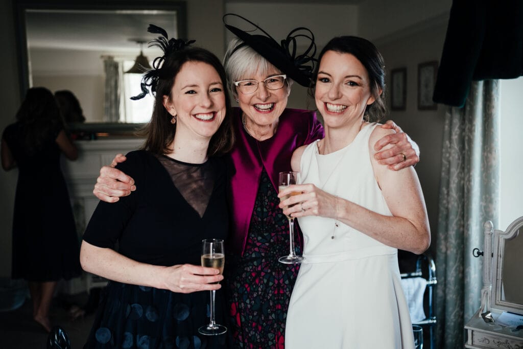 Bride, mum and sister looking at camera and smiling