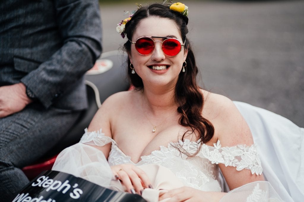 Bride in sidecar wearing red sunglasses