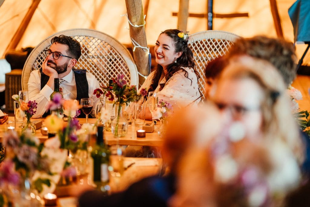bride and groom laughing listening to speeches