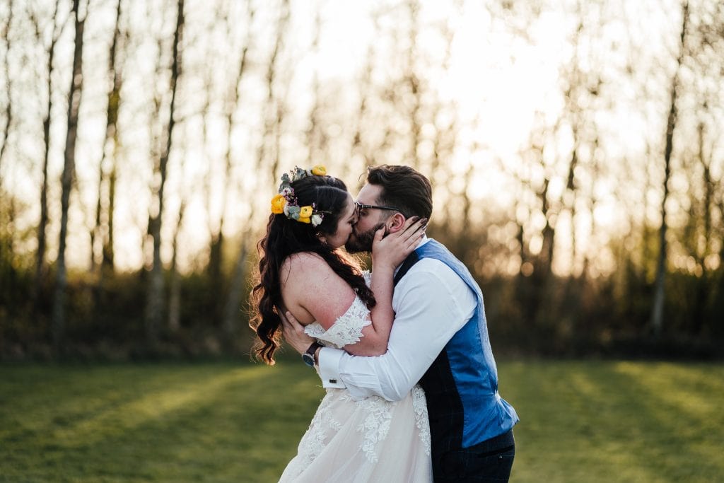 Couple kiss in the evening light during wedding portraits at the Hidden Hive