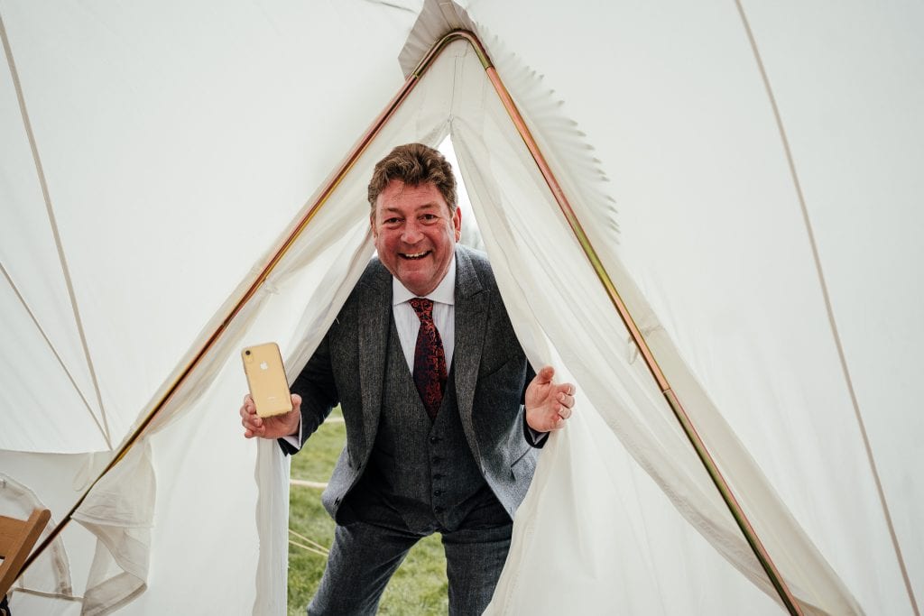 Bride's dad pokes his head through the tent