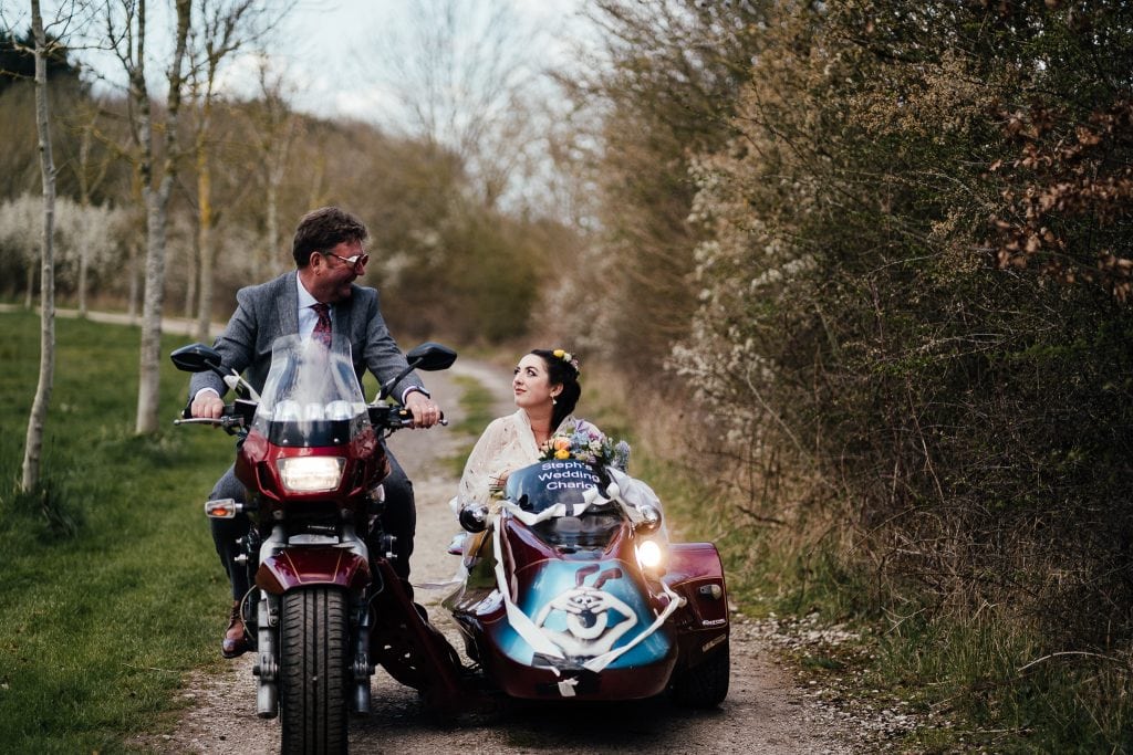 Dad on motorbike looks at bride in sidecar. Wallace and Gromit on front of side car