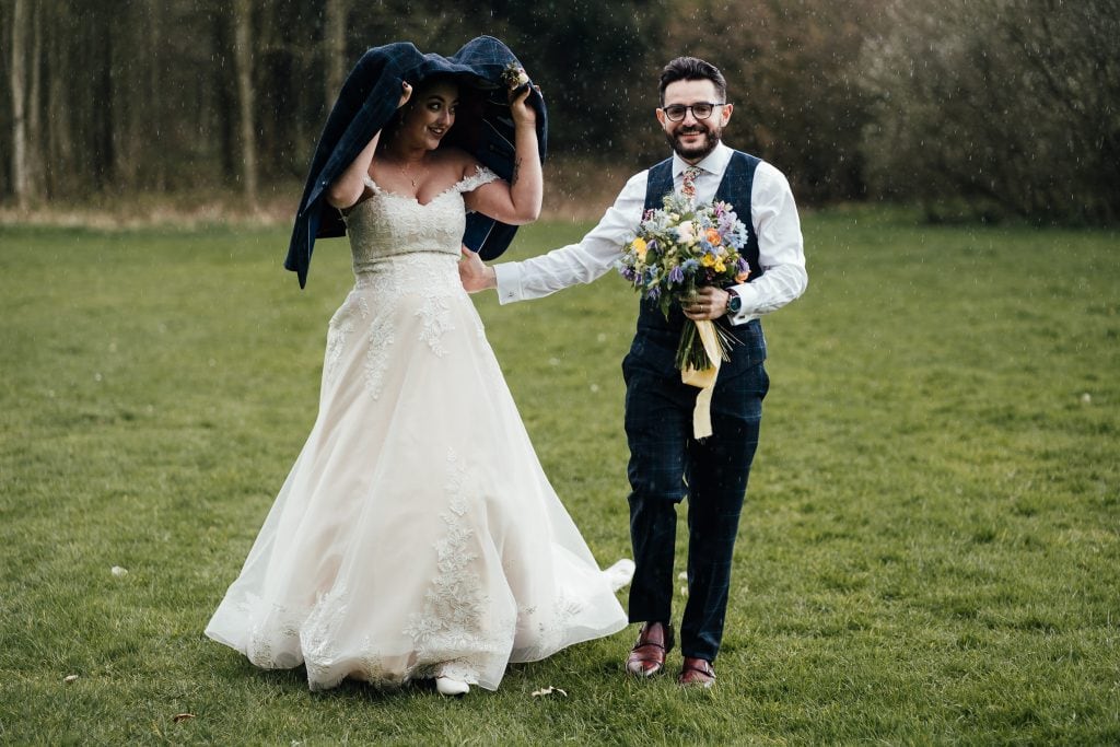 Bride and groom in the rain at The Hidden Hive