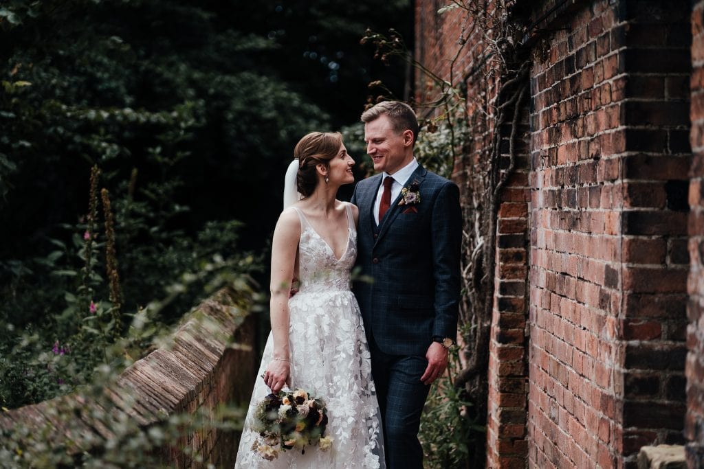 The Mill Hoveringham bride and groom standing by rustic brick wall