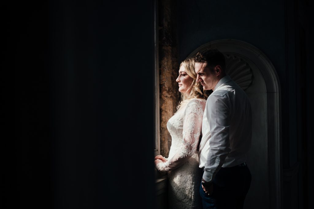 Wollaton Hall wedding. Couple looking out of window in the Prospect Room