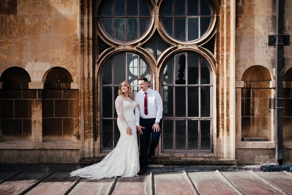 Wollaton Hall wedding: Bride and groom on the roof at Wollaton hall, just standing by the ornate windows