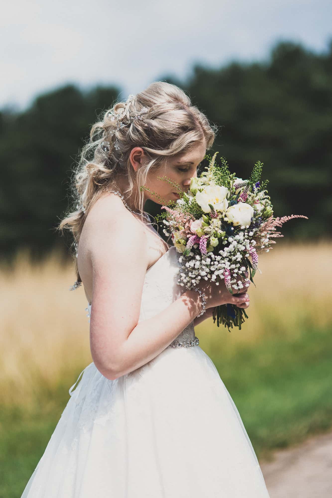 Wedding Photography Inkersall Grange Farm - bride portrait. She sniffs bouquet, eyes closed