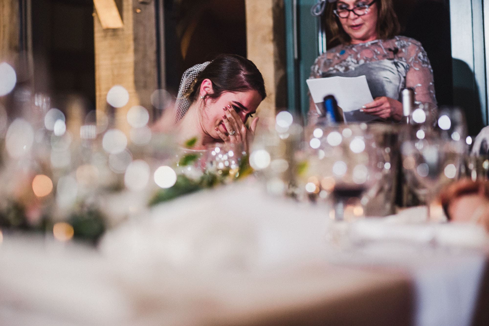Bride crying during her mother's speech in the Oak Room at Hazel Gap Barn