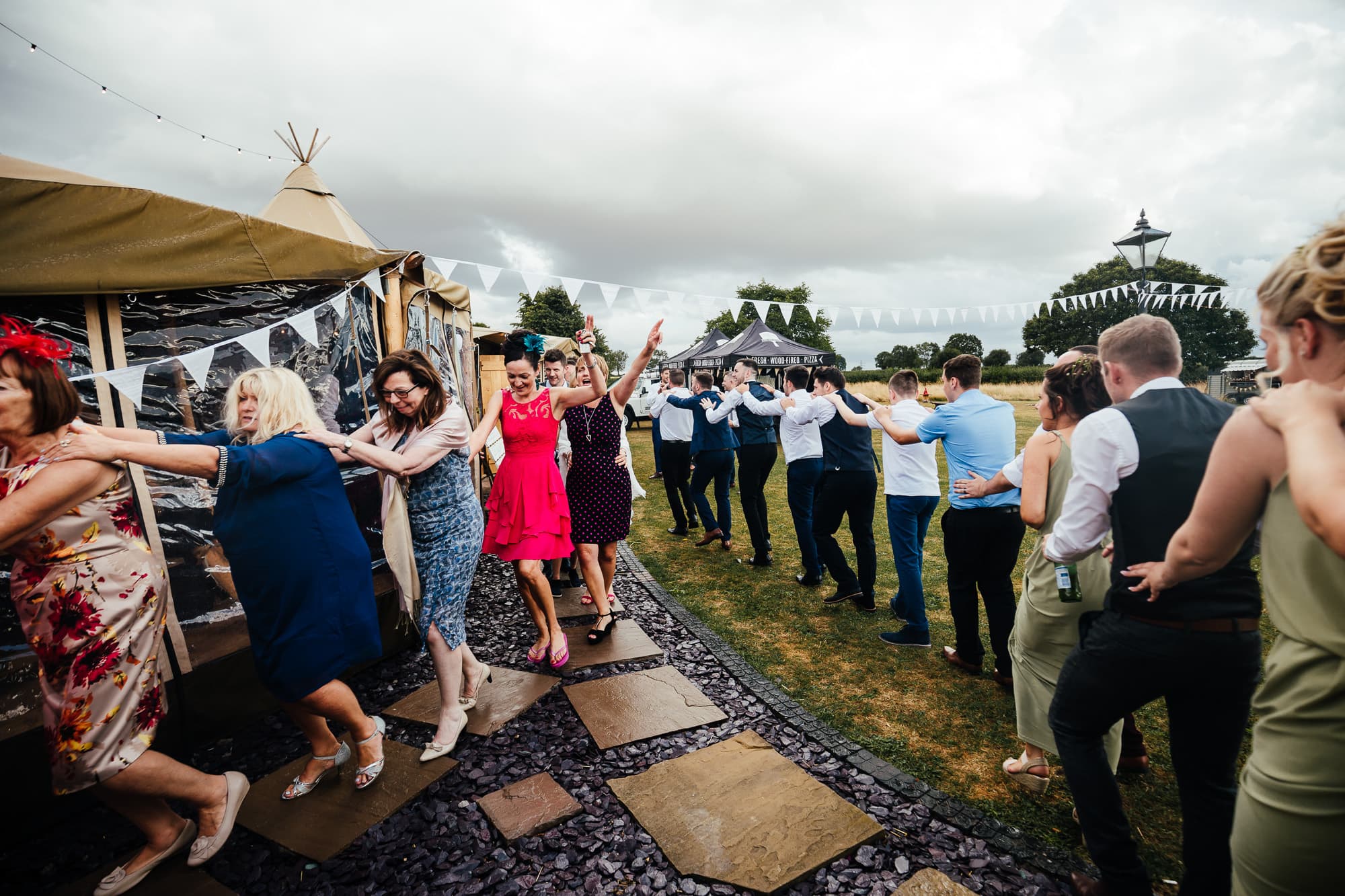Bridge House Barn Wedding - Guests do the conga outs the tipis