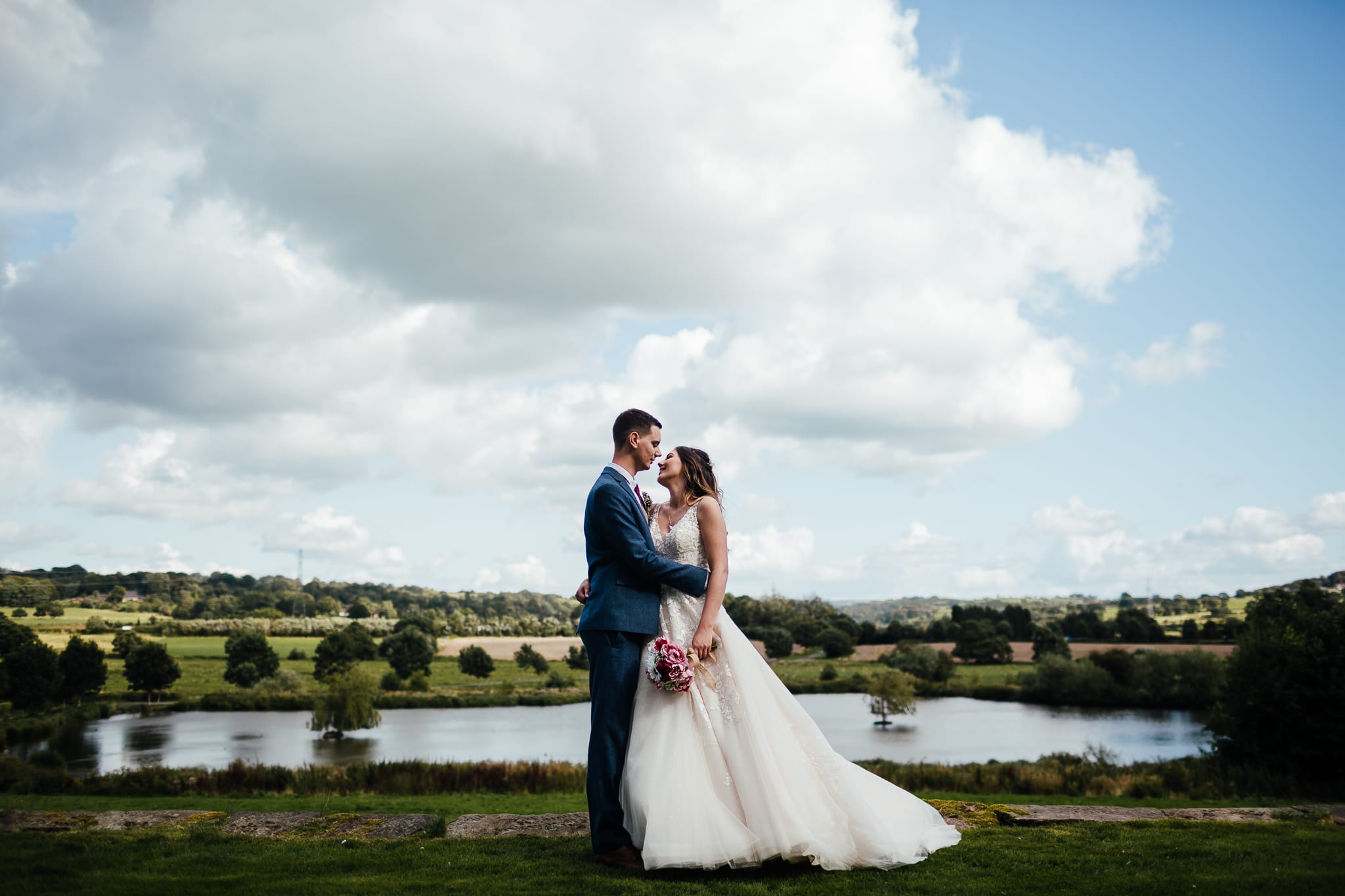 Barn weddings in Nottingham - Bride and Groom portrait in front of the pond at the Ashes Barns