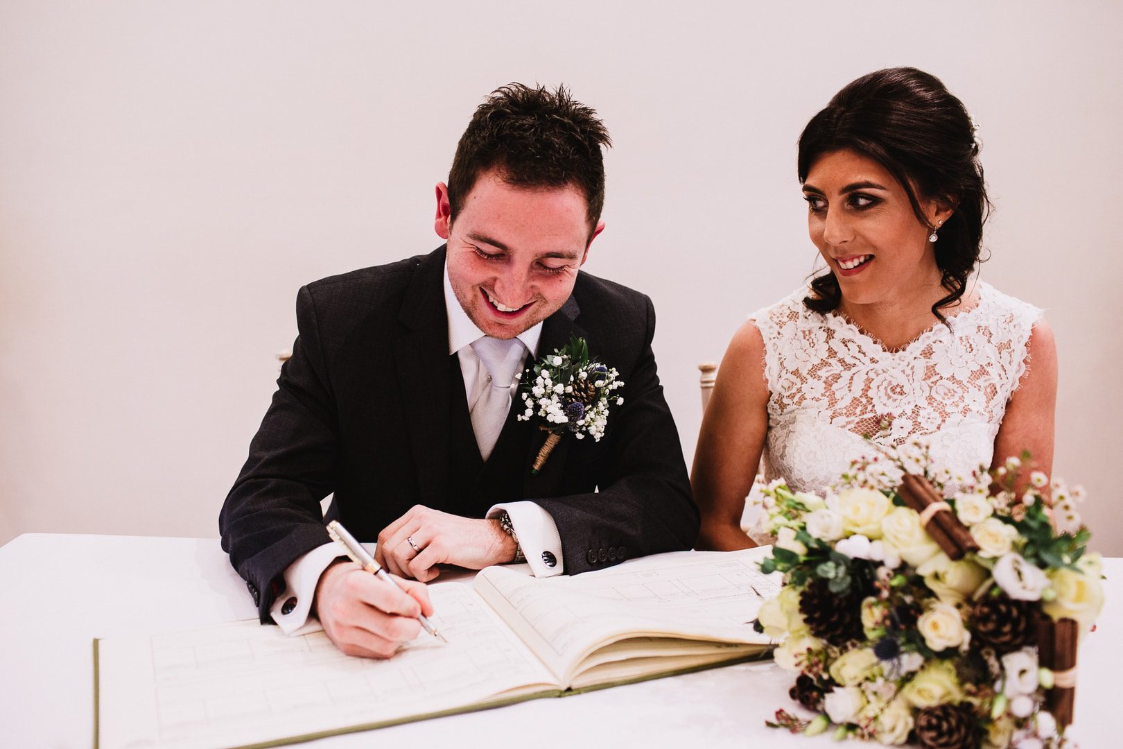 bride and groom sign the register at Rufford Mill