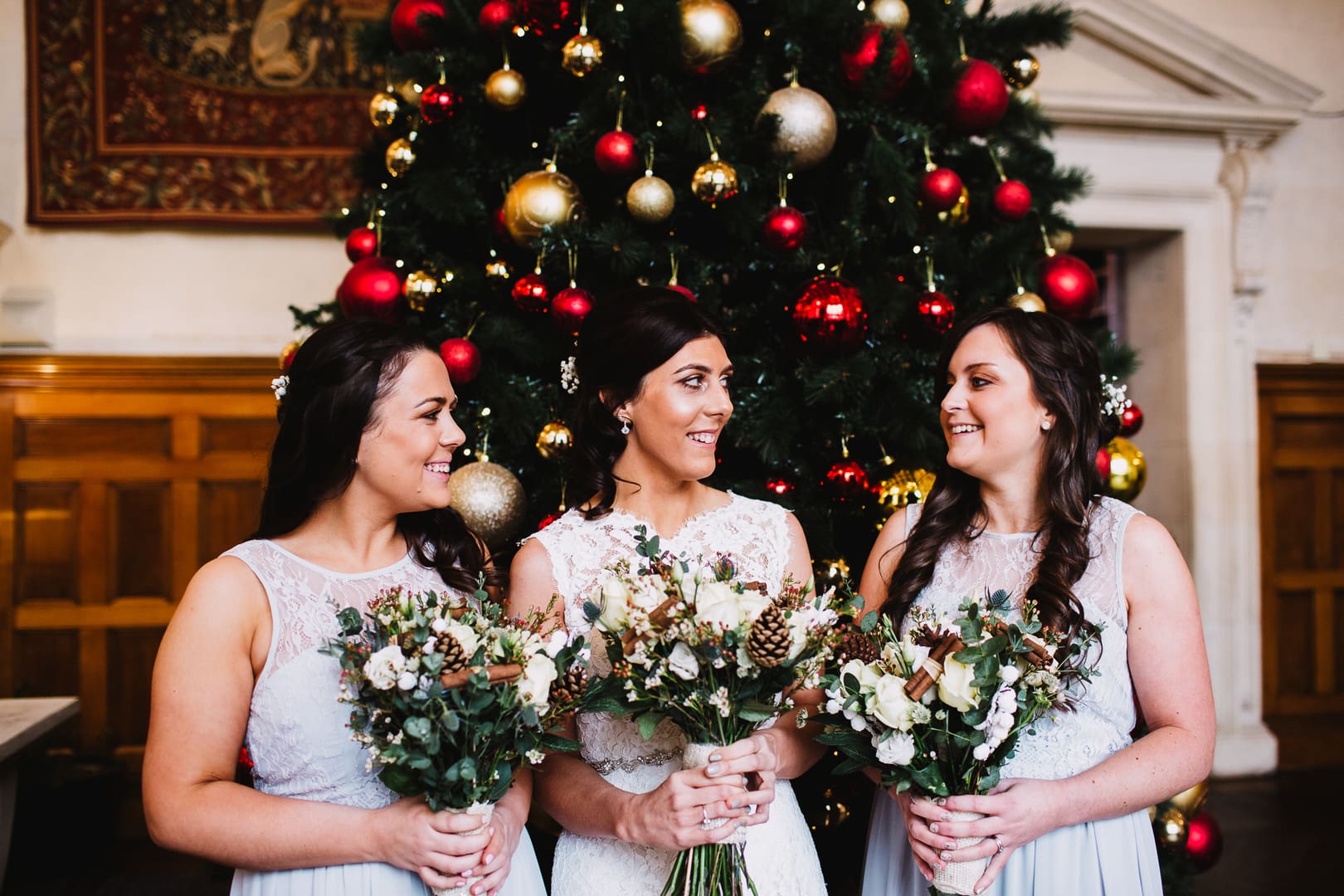bride and bridesmaids in front of Christmas tree 