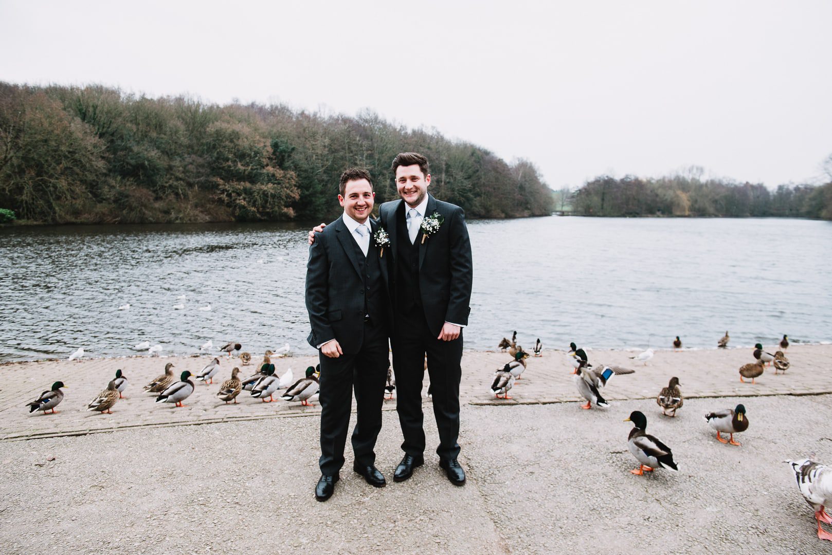 wedding photography at Rufford Mill - groom and best man surrounded by ducks