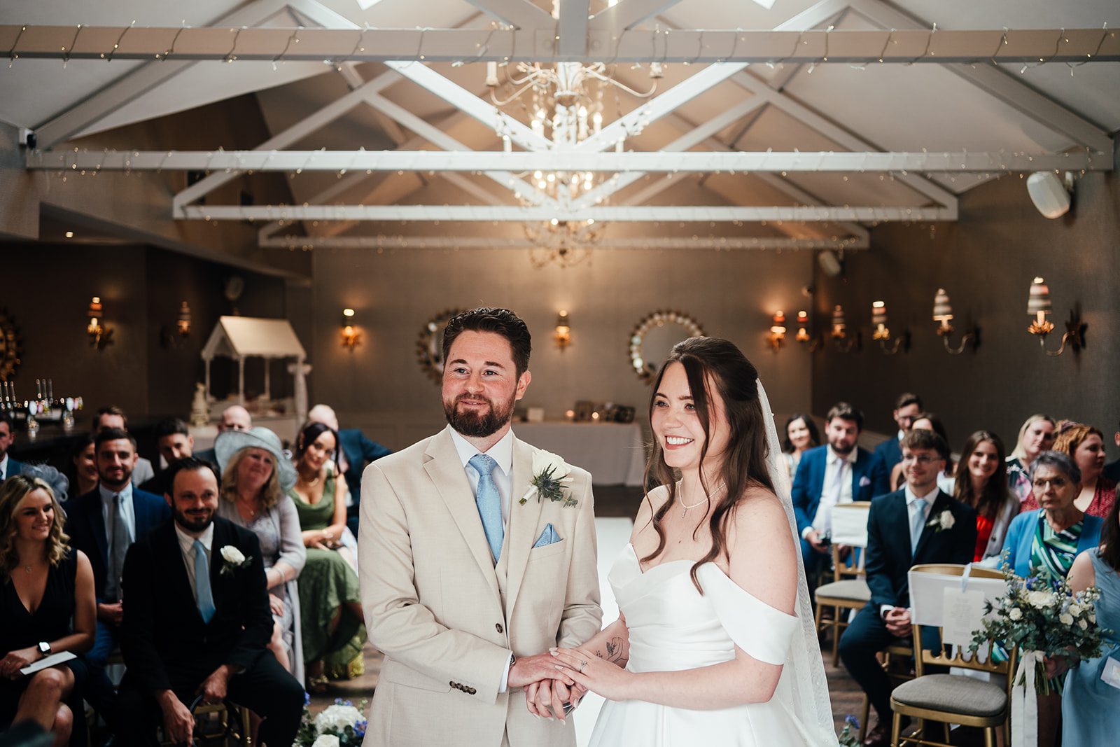 Bride and groom stand holding hands at the top of the aisle at Cockliffe Country House wedding venue
