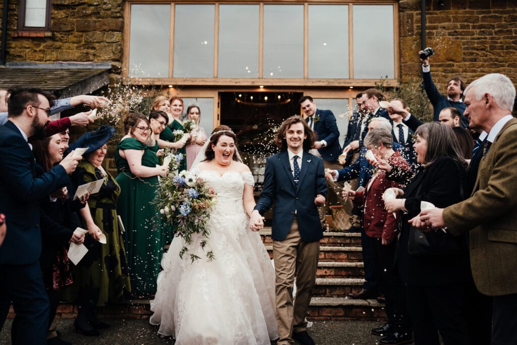 Bride and groom in confetti at rustic pagan wedding Crockwell Farm