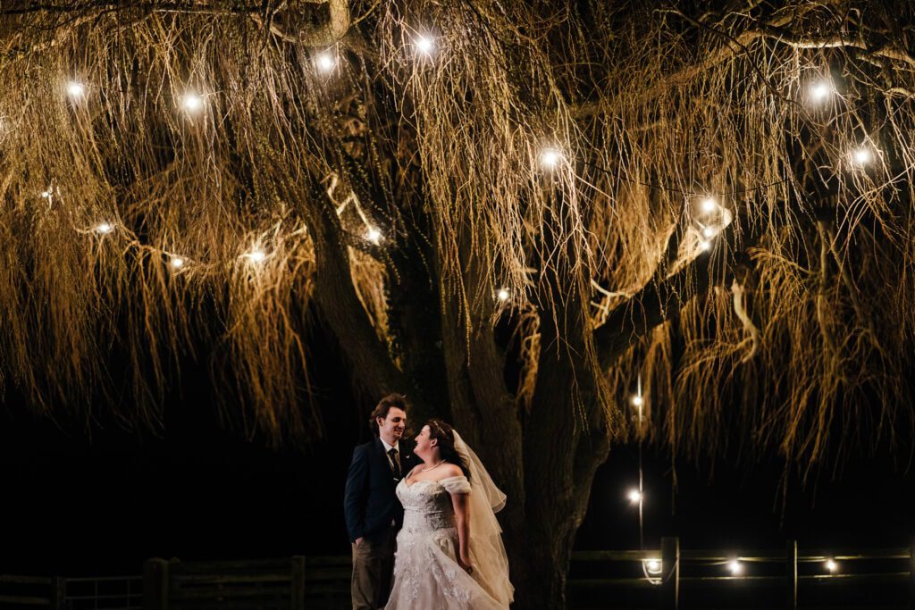 bride and groom night time portraits under weeping willow at Crockwell farm