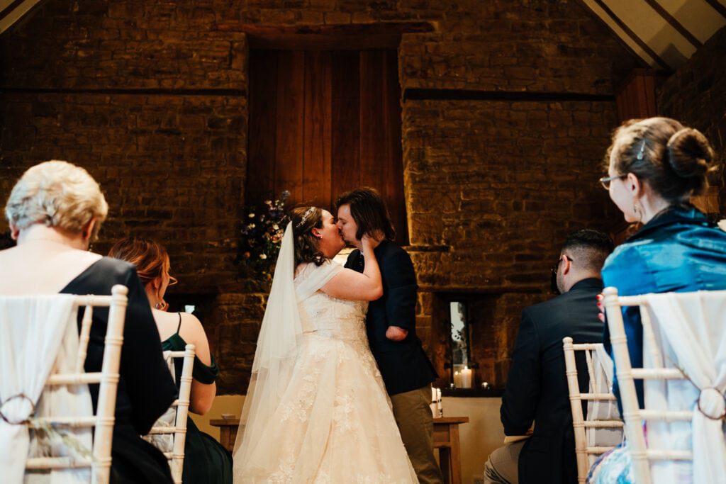bride and groom share first kiss