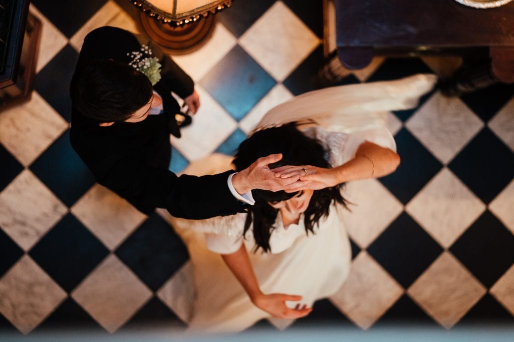 Wedding Photography at The Cosy Club Nottingham. Bride and groom dance on black and white tiles. Photo from above - looking down on them.