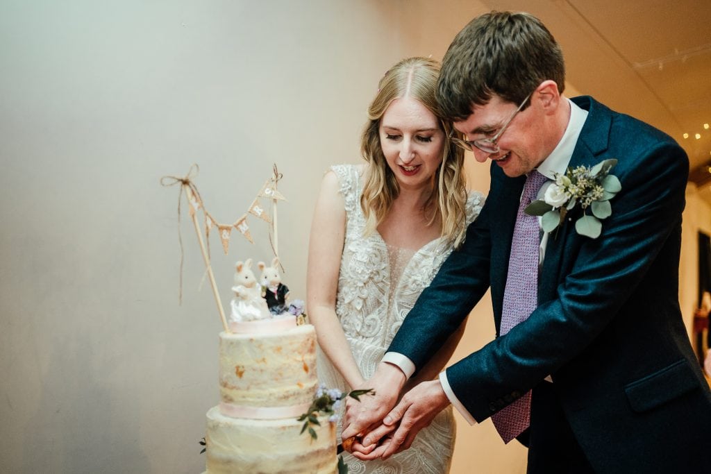 bride and groom cut cake at their wedding at the Manor House Quorn
