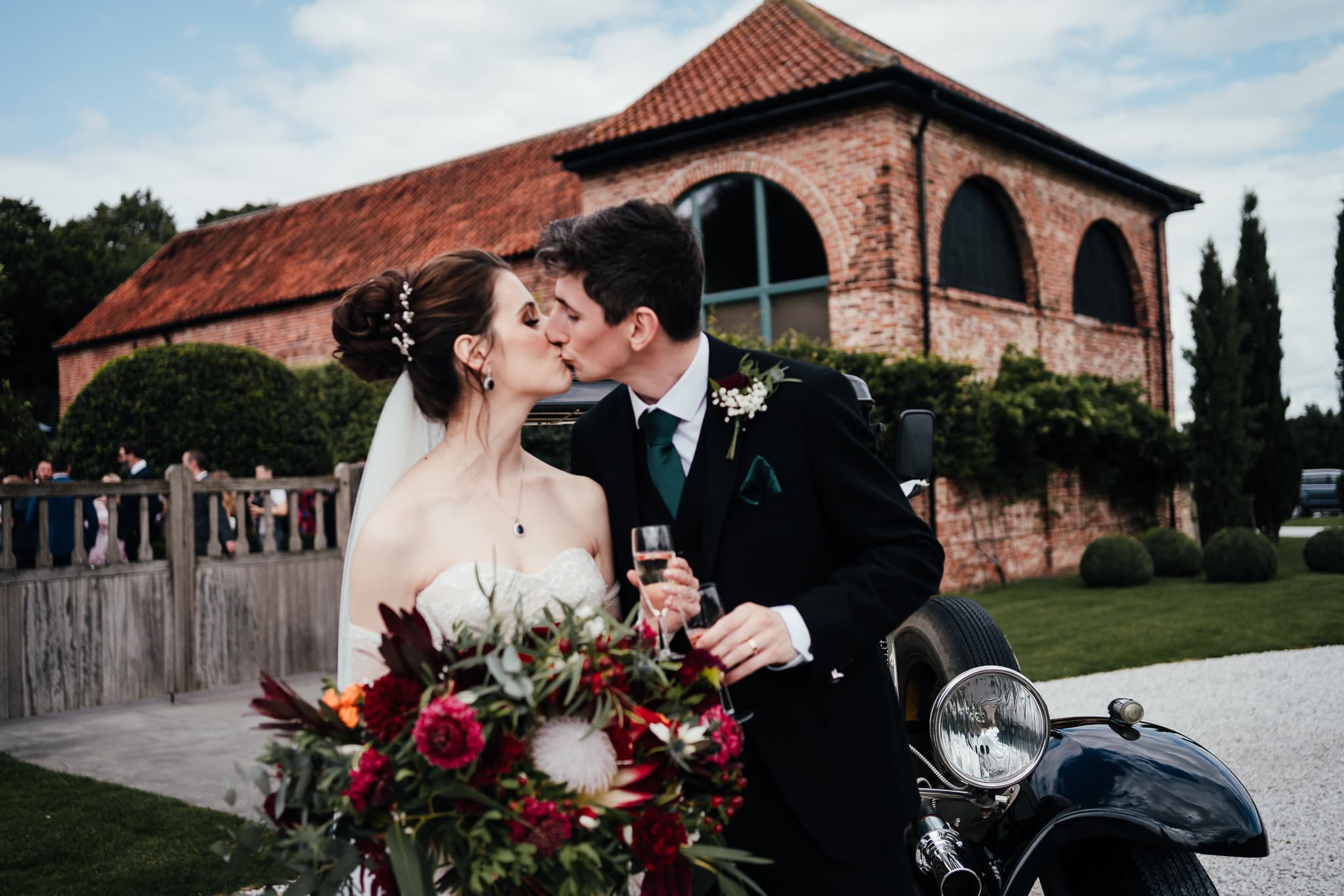 Nottingham wedding venues - couple kiss outside of Hazel Gap Barn
