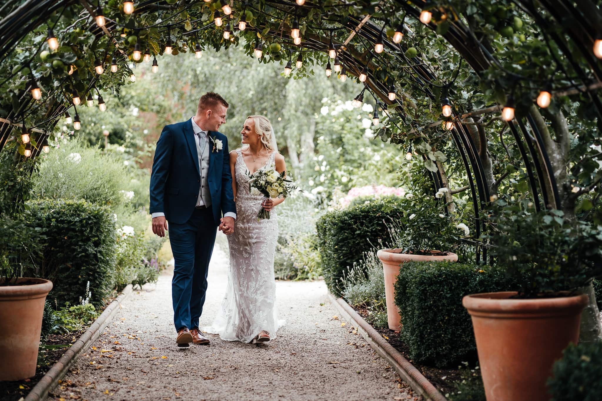 Nottingham's lovely wedding venue. Pippley Walled Garden. Couple walking under archway