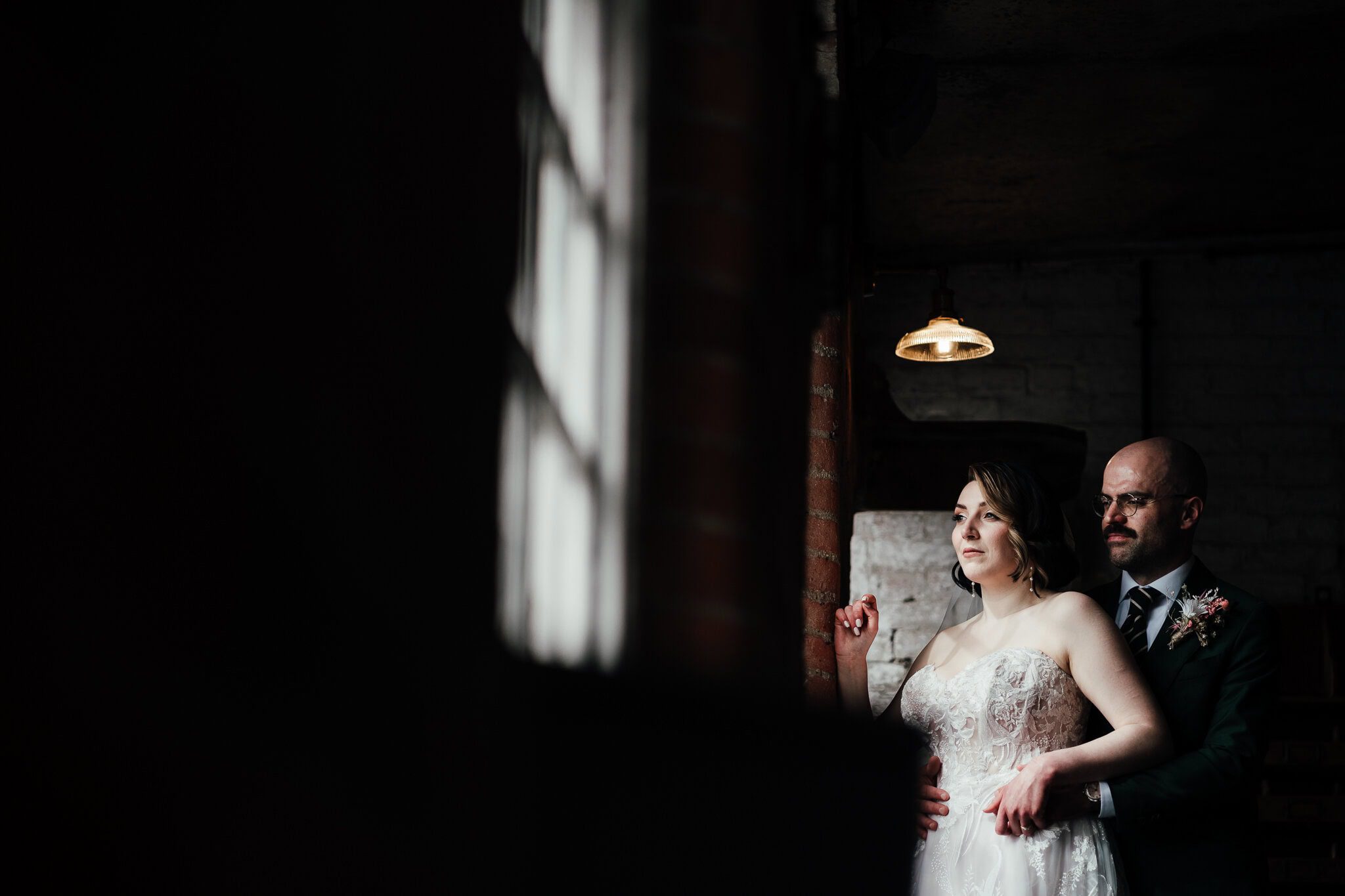 Bride and groom portrait by the large windows in The West Mill wedding venue