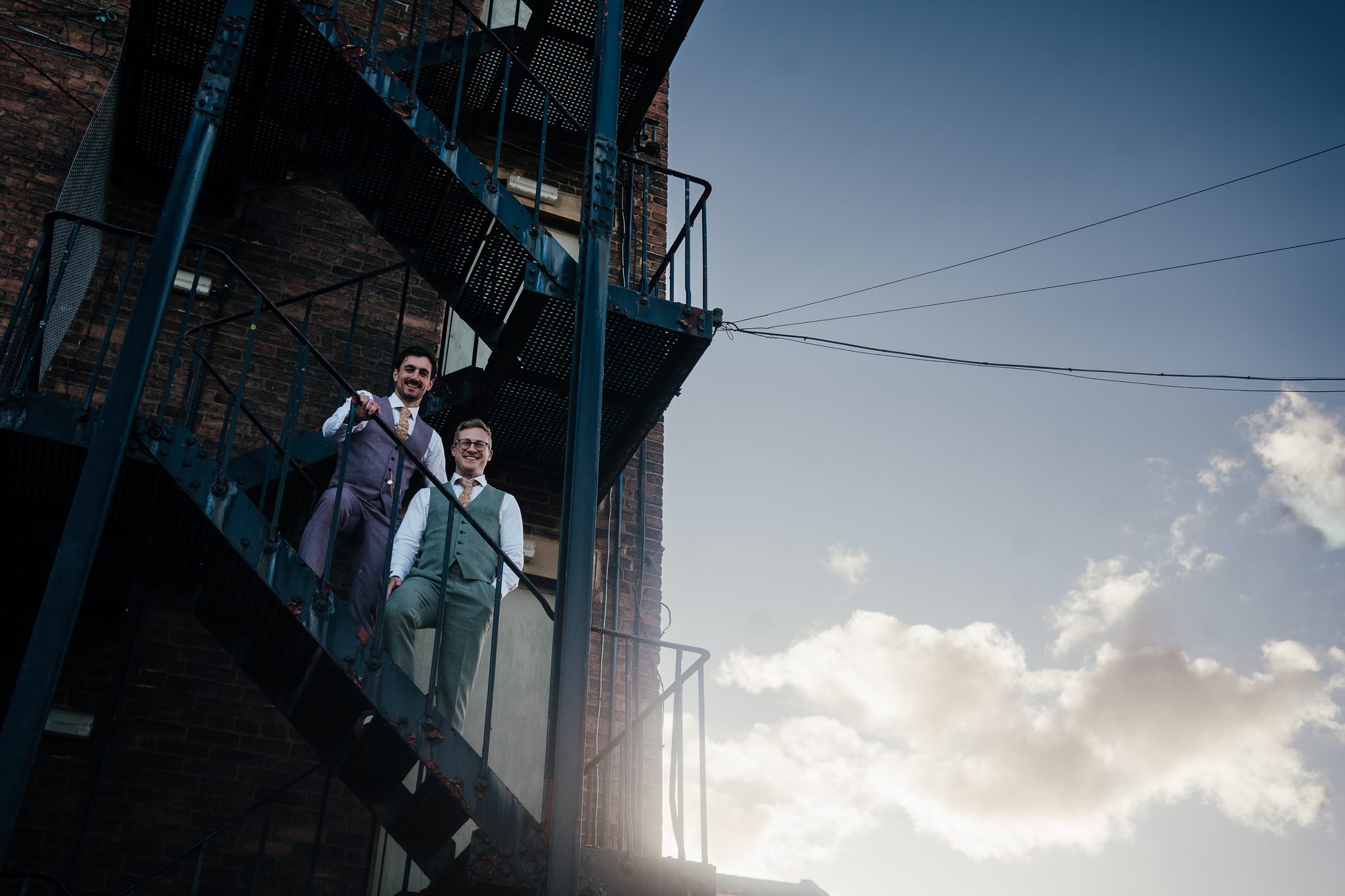 Two grooms on the fire escape behind the west mill during sunset