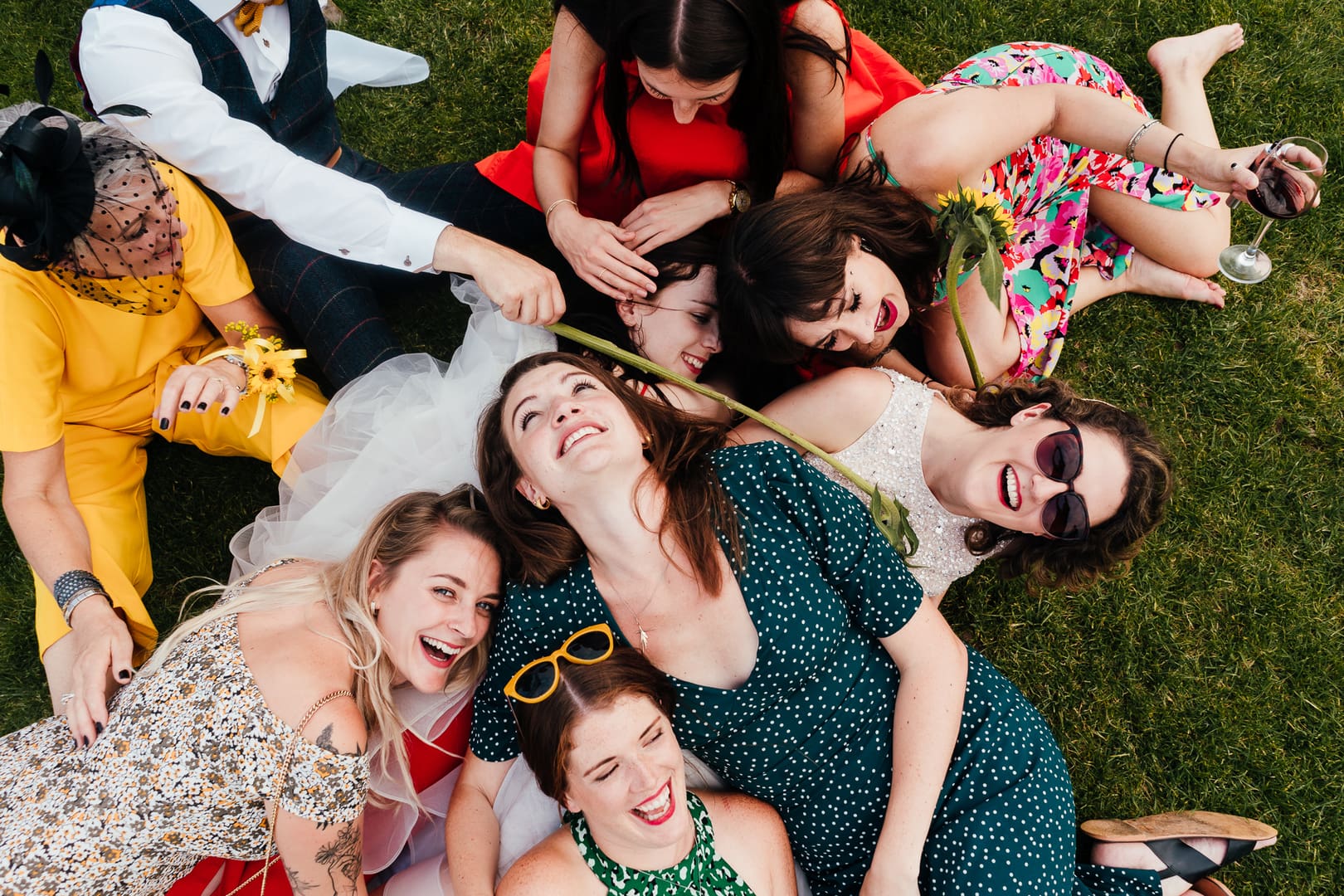 Nottingham Wedding Photographer captures Bride and friends laughing lying in the grass - falling over each other